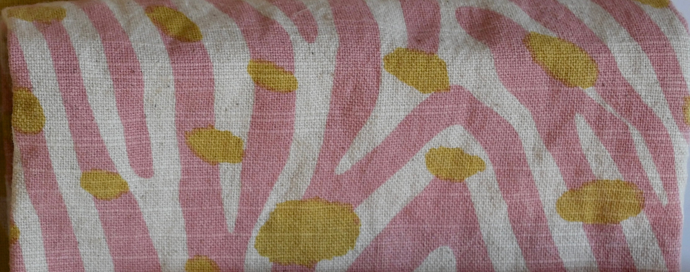 Fabric with pink and white striped pattern and yellow spots