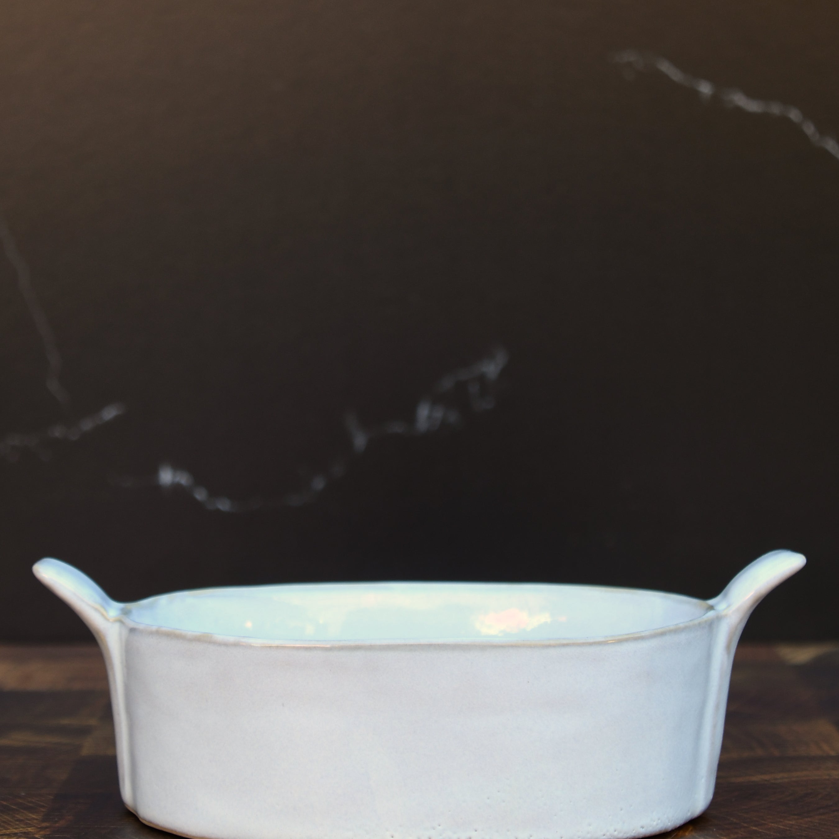 Stoneware baker with handles. White glaze. Dishwasher, oven and microwave safe.