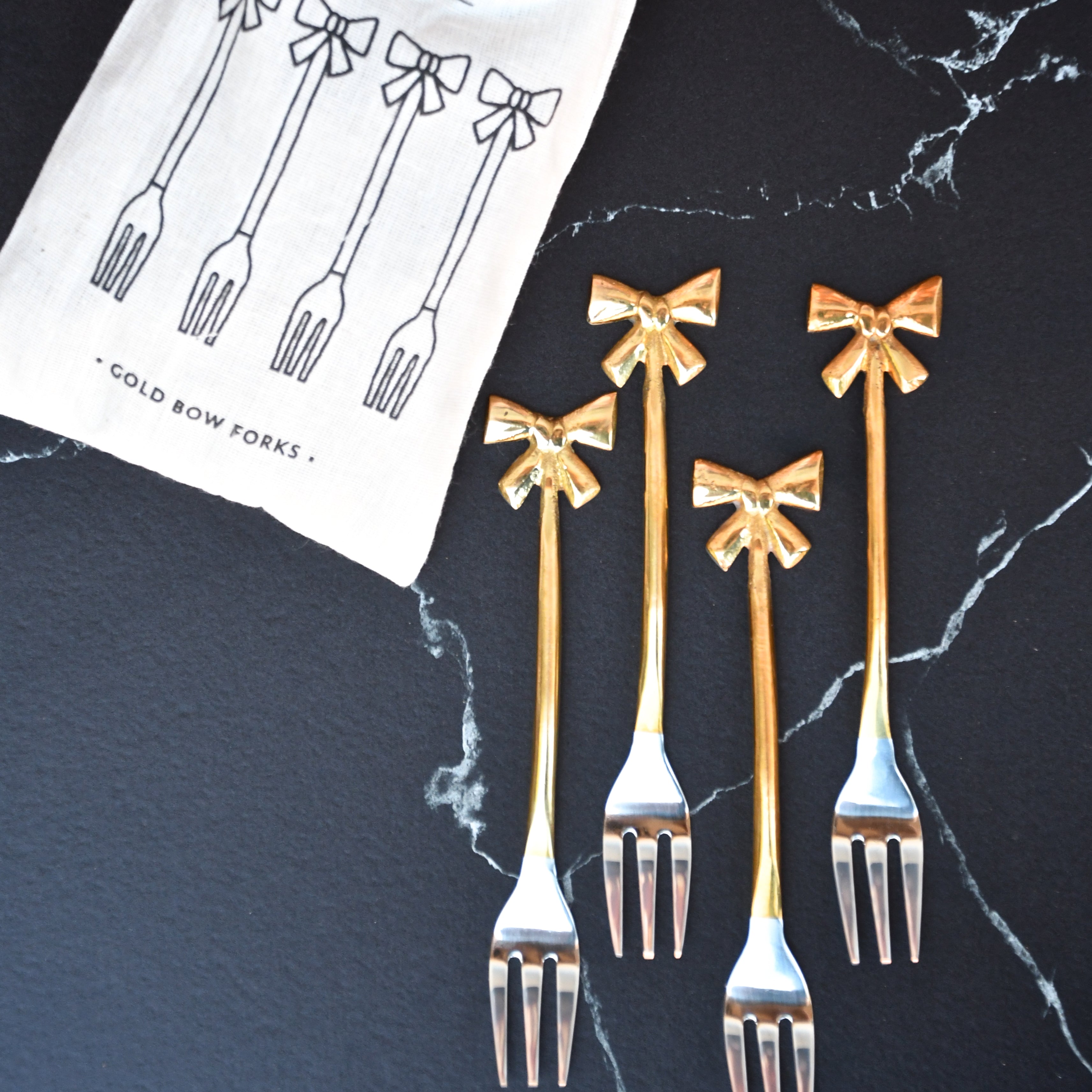 set of 4 small forks with gold bows on handle.