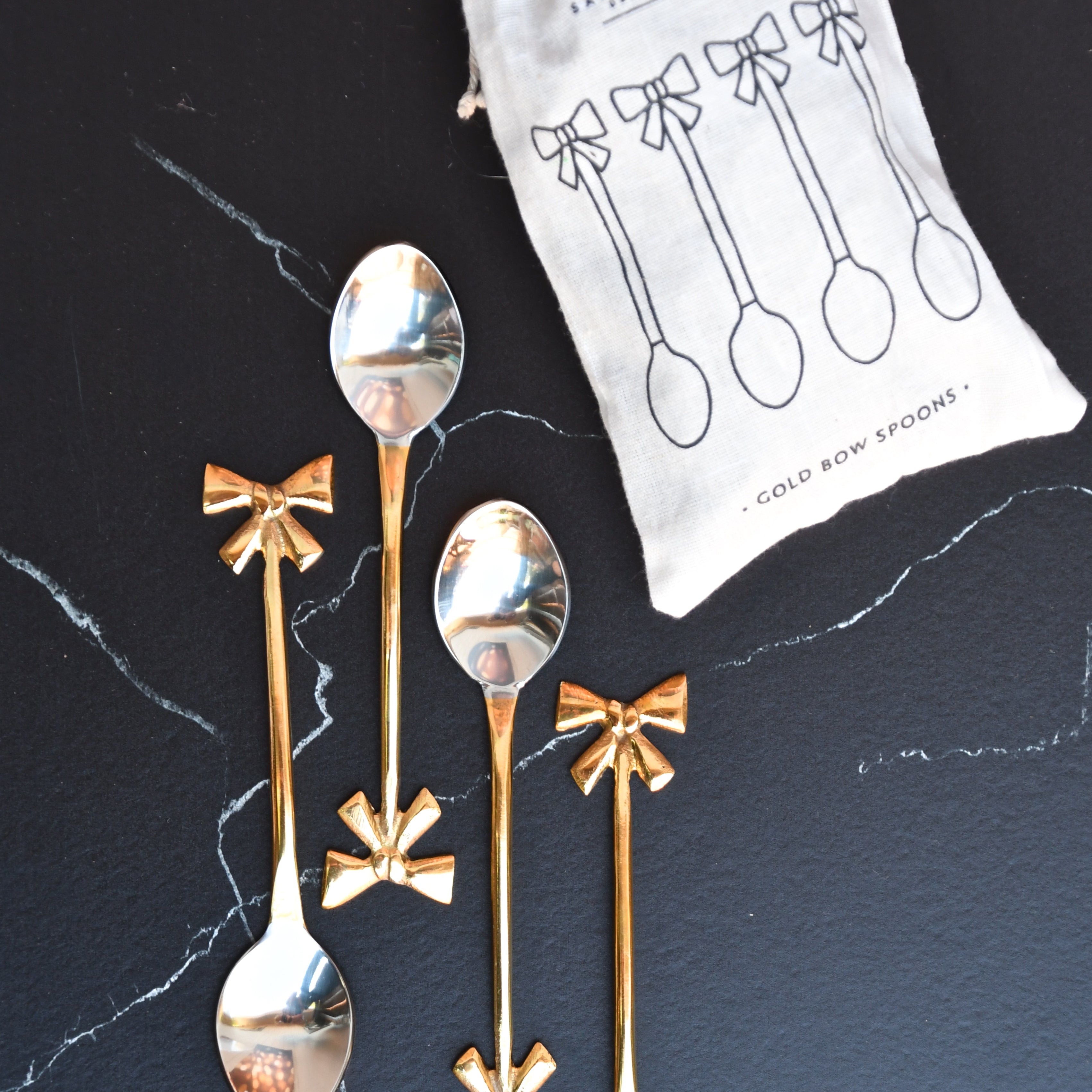 set of 4 gold bow spoons. Gold bow handle.