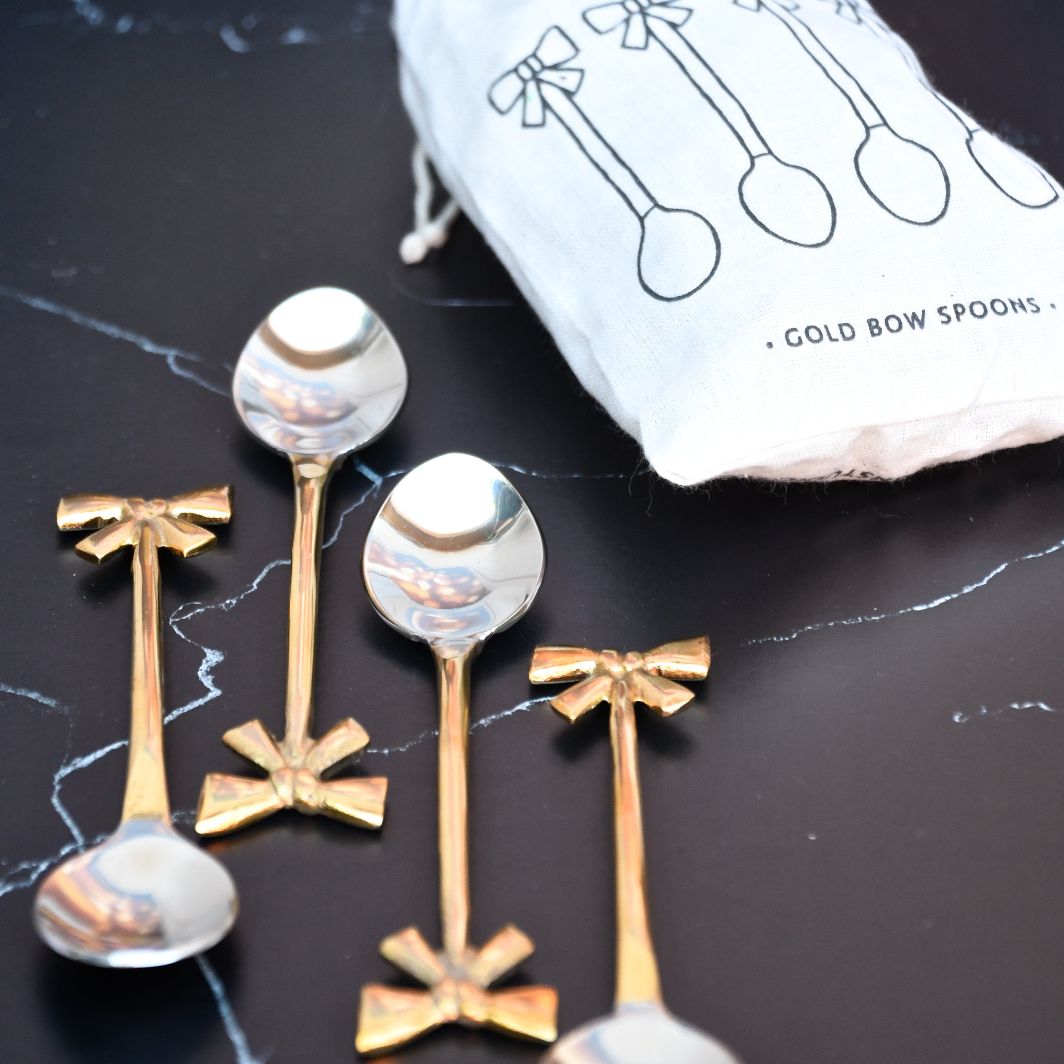 set of 4 gold bow spoons. Gold bow handle.