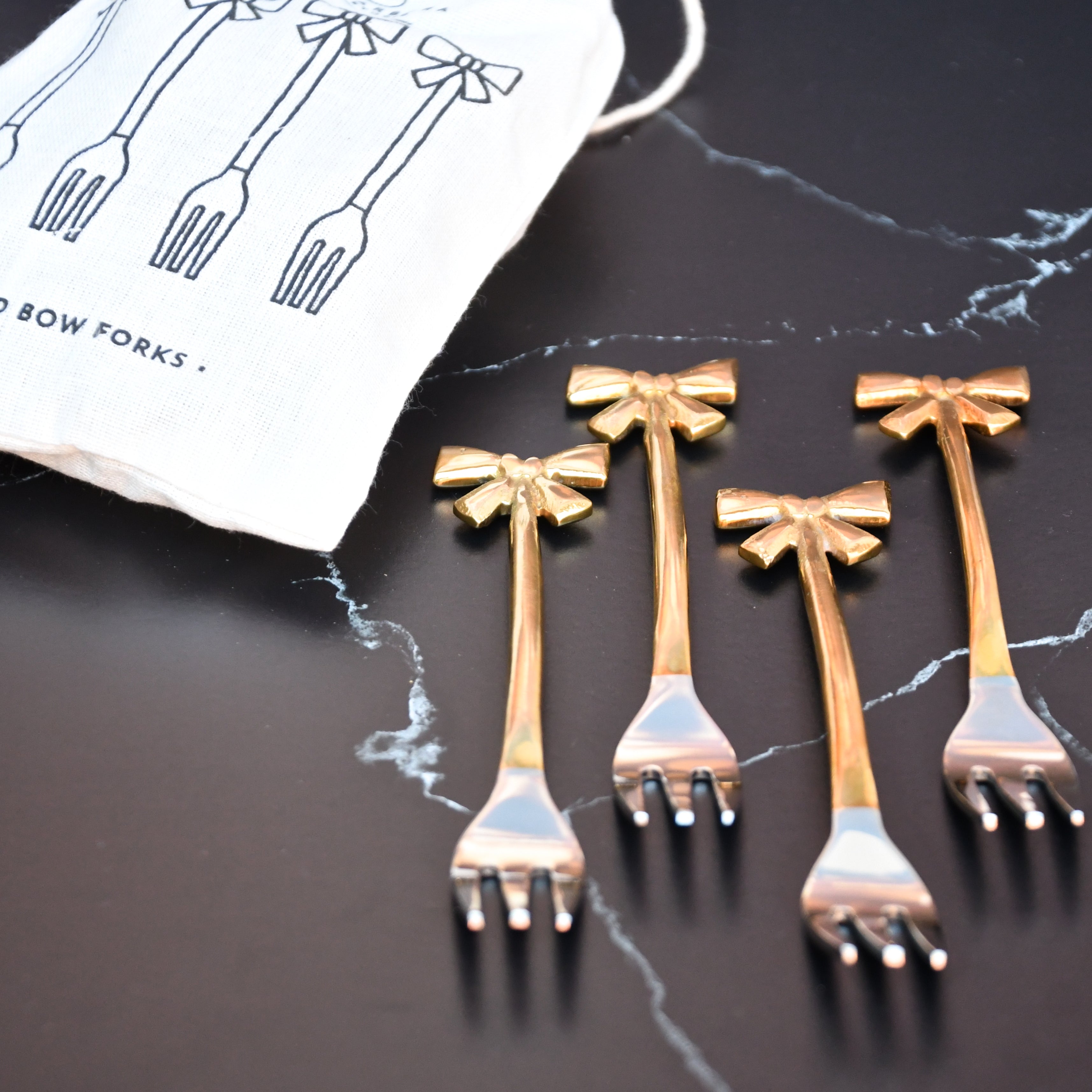 set of 4 small forks with gold bows on handle.