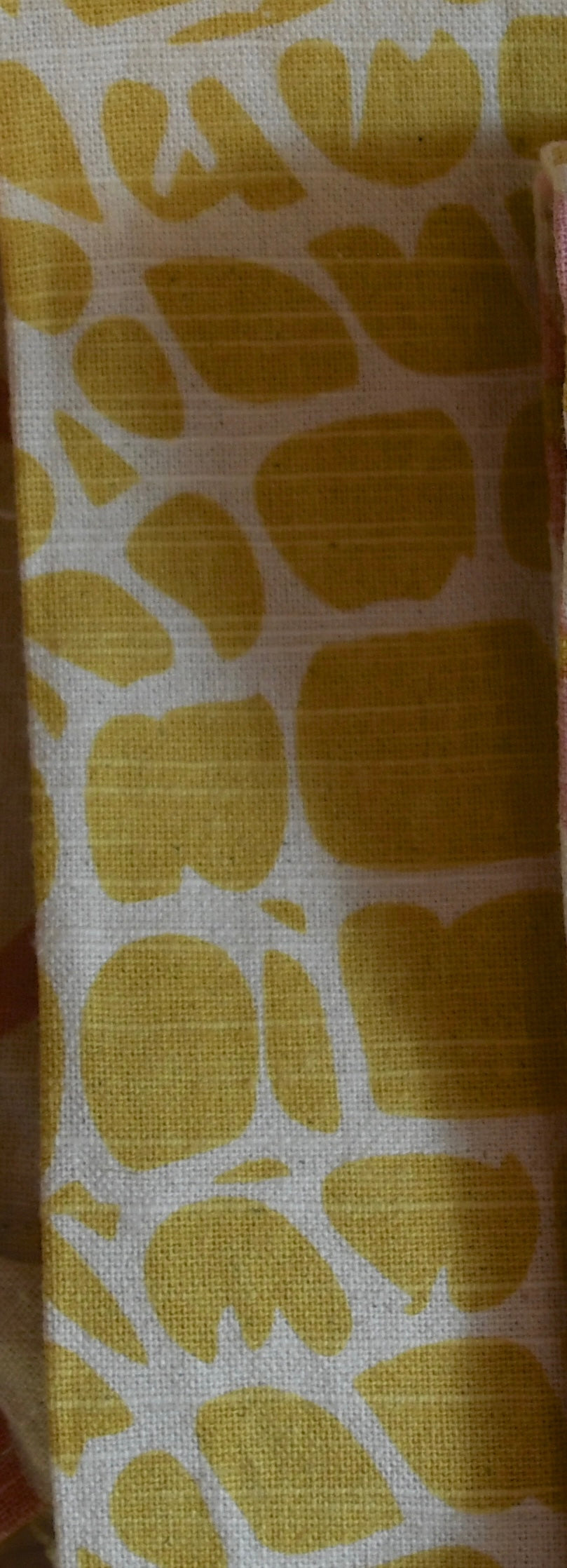 Fabric with yellow leaf pattern on a white background