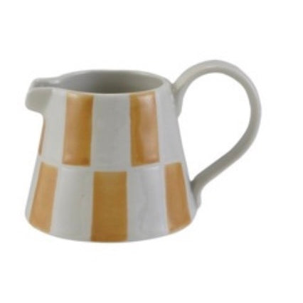 Ceramic pitcher with gold and white striped design on a white background