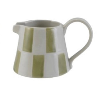 Ceramic pitcher with green and white striped design on a white background