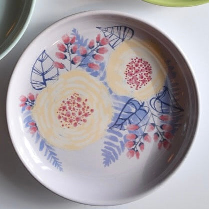 Decorative ceramic plate with floral design on a white surface