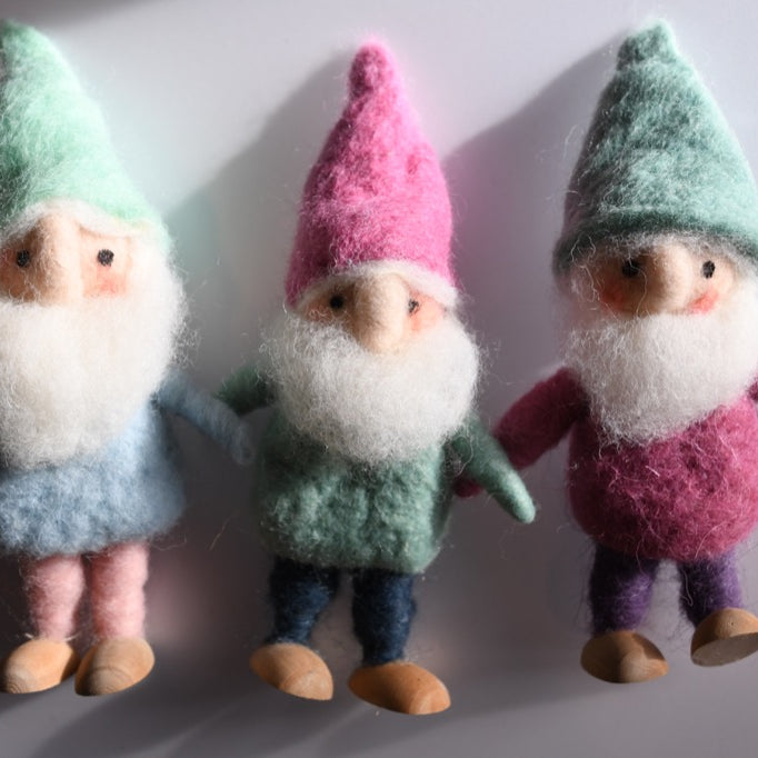 Three gnome figurines with colorful hats on a white background