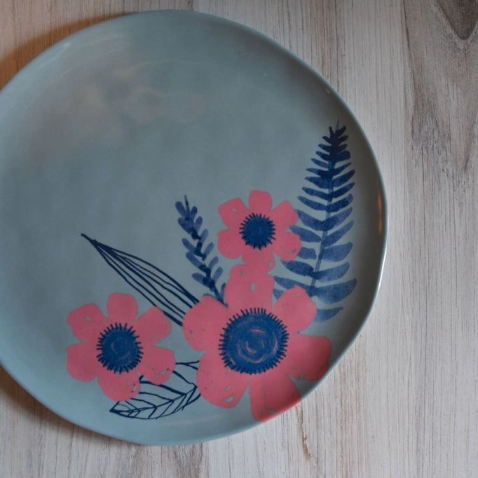 Round plate with floral design on a wooden surface