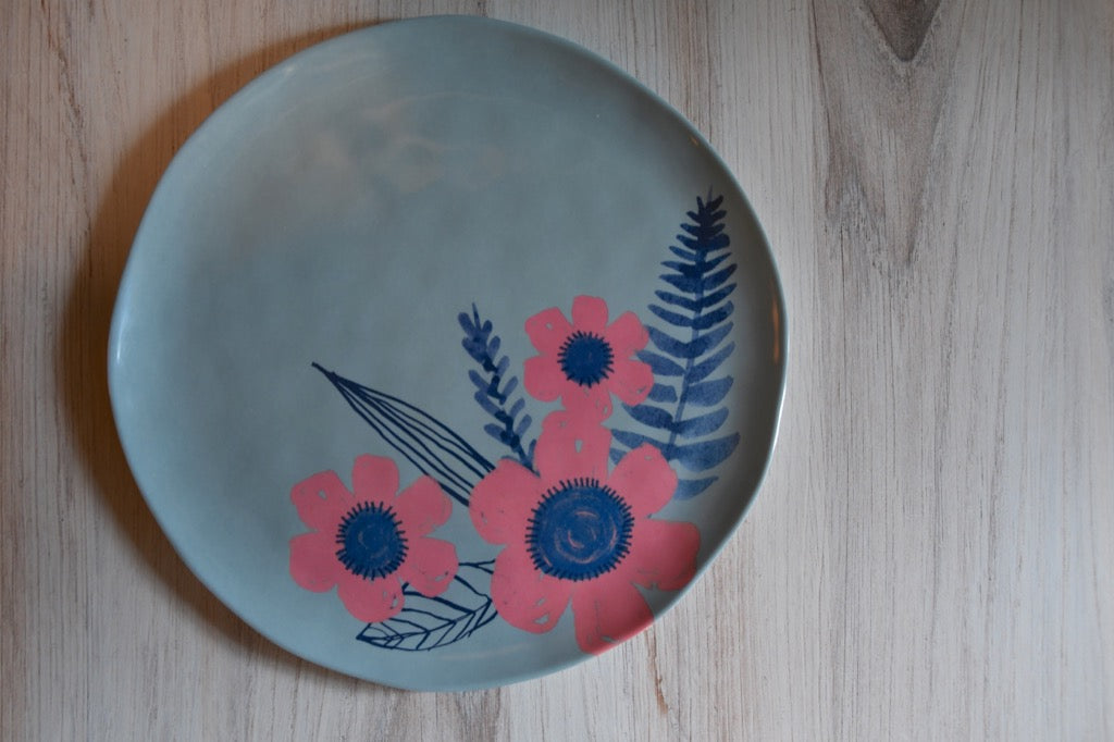Round plate with floral design on a wooden surface