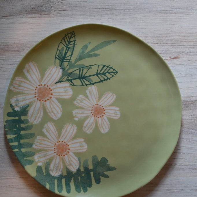 Decorative plate with floral design on a wooden surface