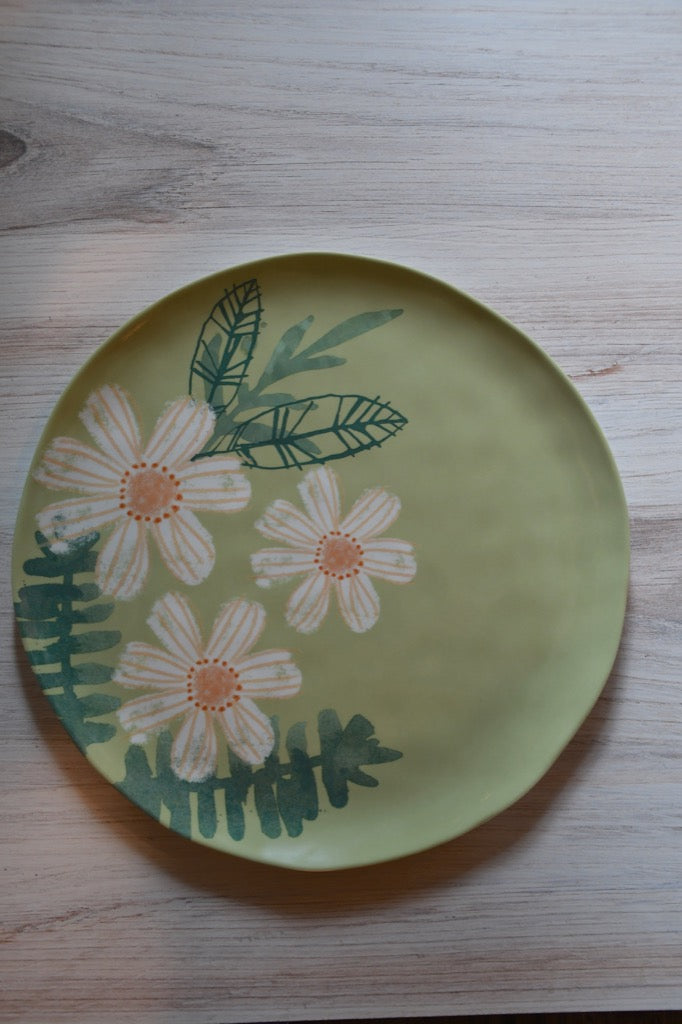 Decorative plate with floral design on a wooden surface