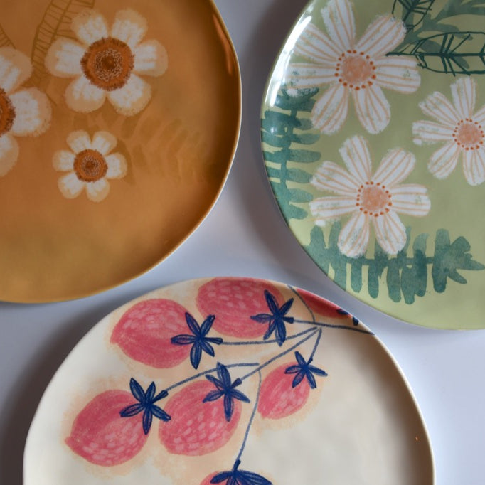 Three plates with floral designs on a white background