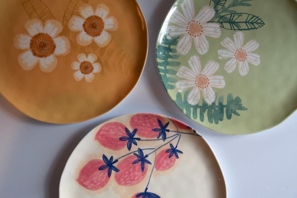 Three plates with floral designs on a white background
