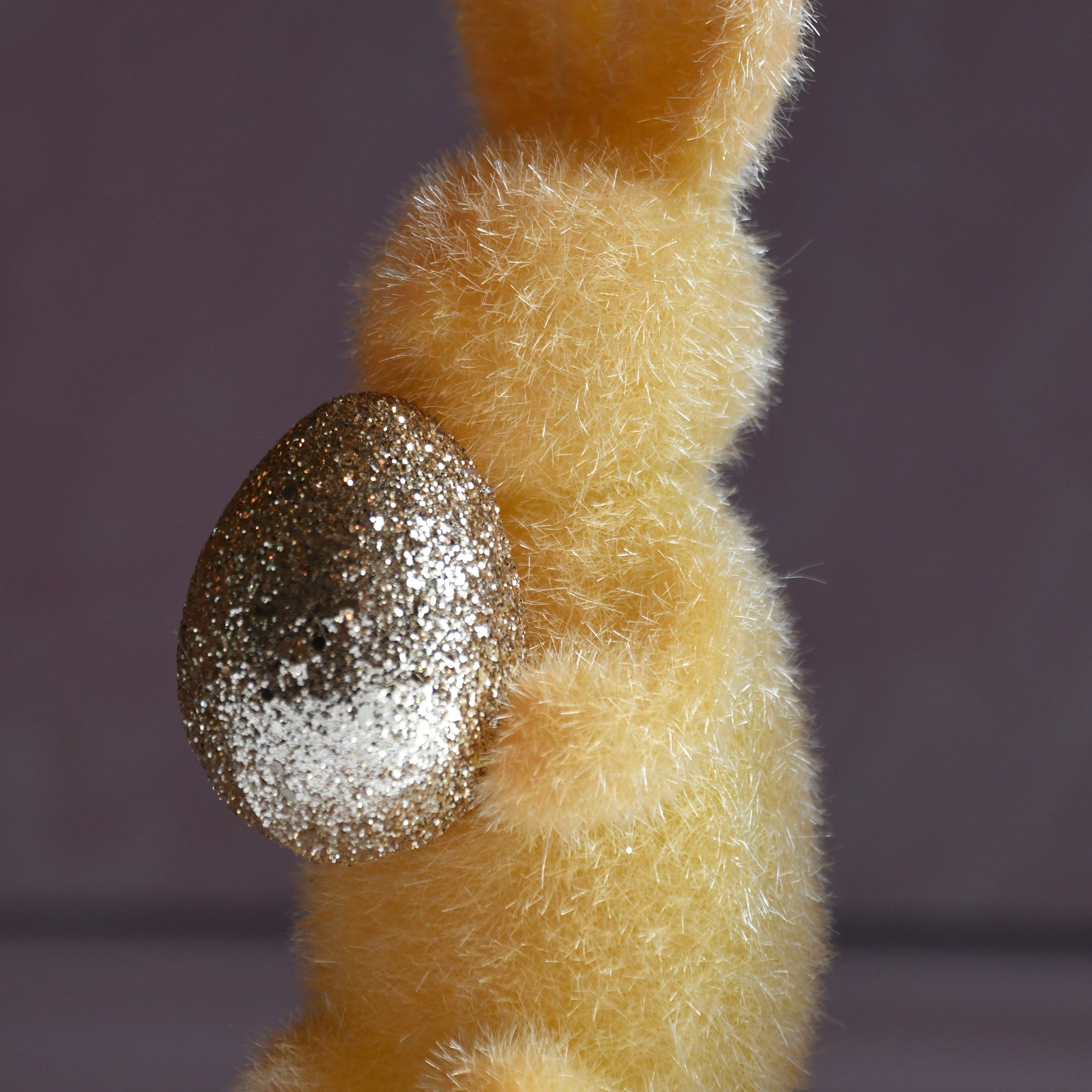 Plush bunny with a glittery egg on a plain background