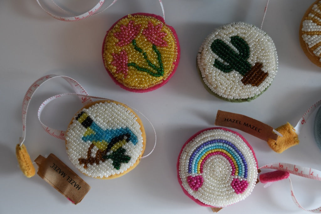 Decorative tape measure with beadwork designs on a white surface