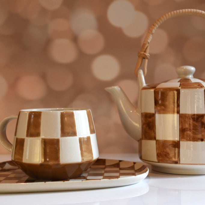 Ceramic tea set with checkered pattern on a blurred background