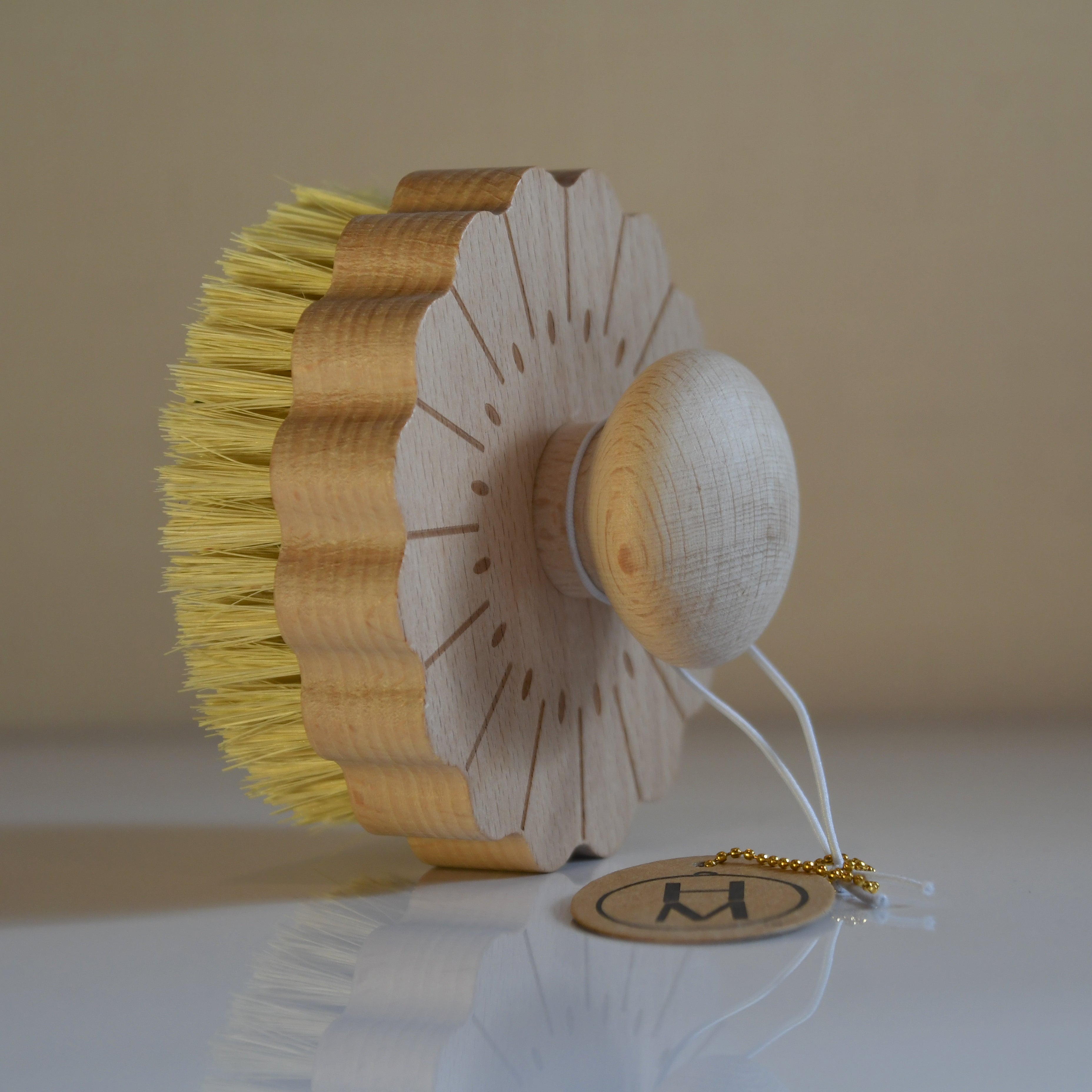 Decorative item with yellow bristles and white base on a beige background