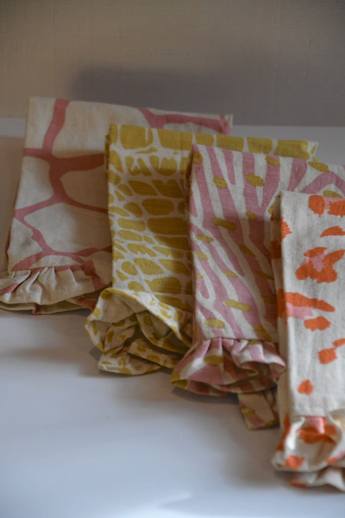 Four patterned fabric swatches on a white surface