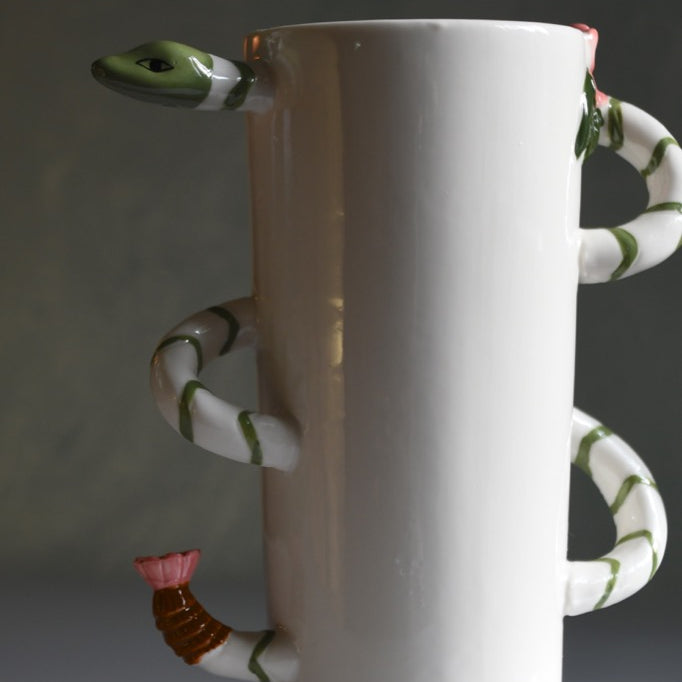 White ceramic vase with snake-like handles on a gray background
