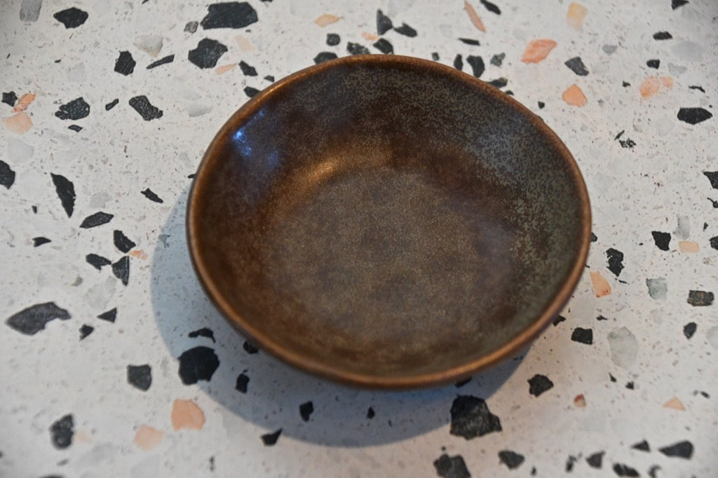 Brown ceramic bowl on a speckled countertop