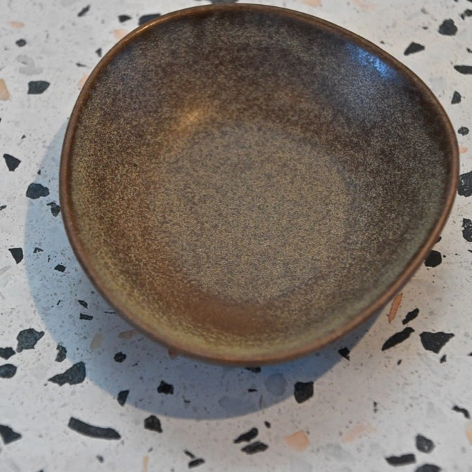 Brown ceramic plate on a speckled countertop