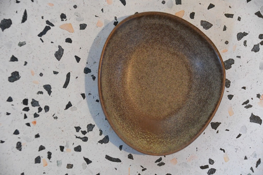 Brown ceramic plate on a speckled gray surface