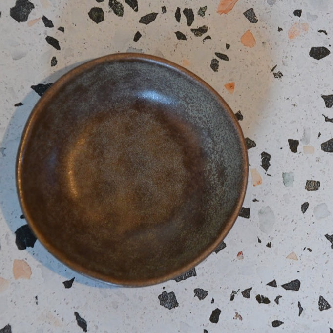 Brown ceramic bowl on a terrazzo countertop