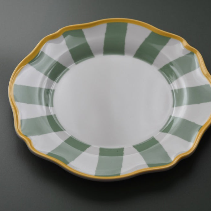 Decorative plate with green and gold rim on a dark background