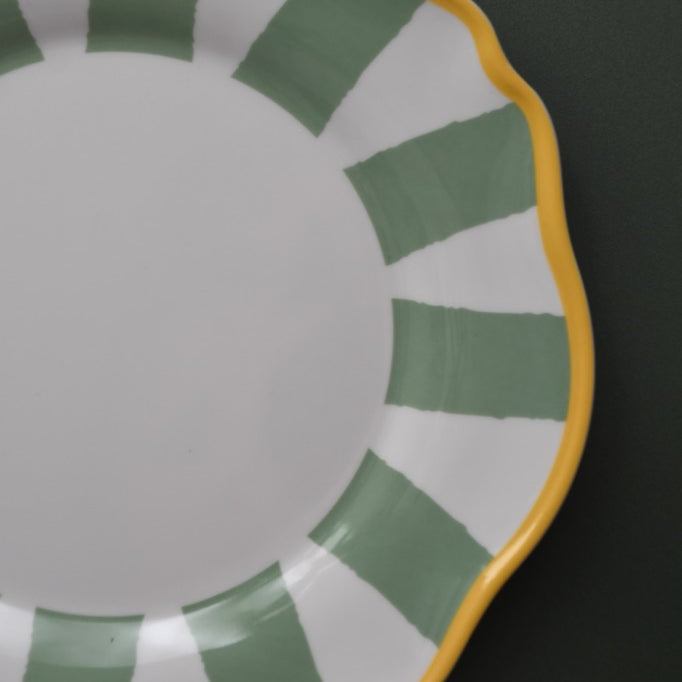 Ceramic plate with green and yellow design on a black background