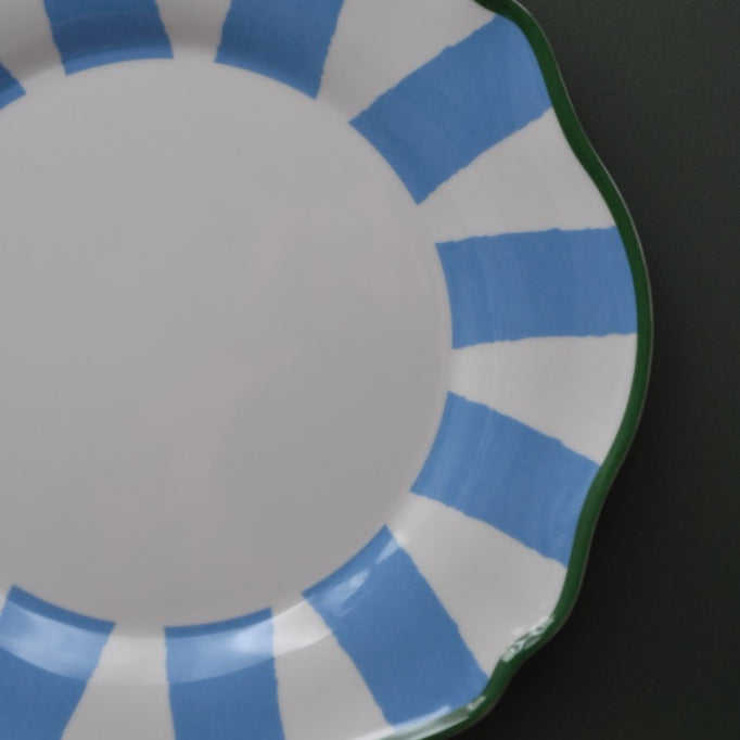 Plastic plate with blue and white striped rim on a black background