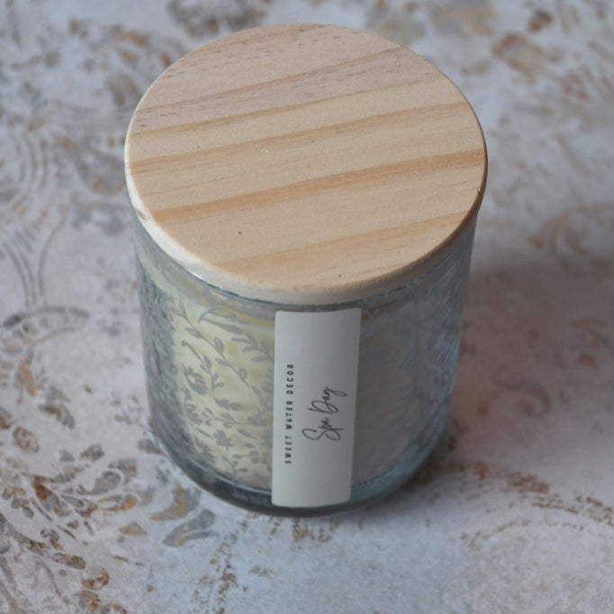 Glass jar with wooden lid on a textured surface
