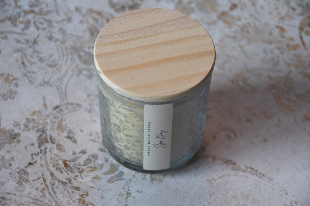 Glass jar with wooden lid on a textured surface
