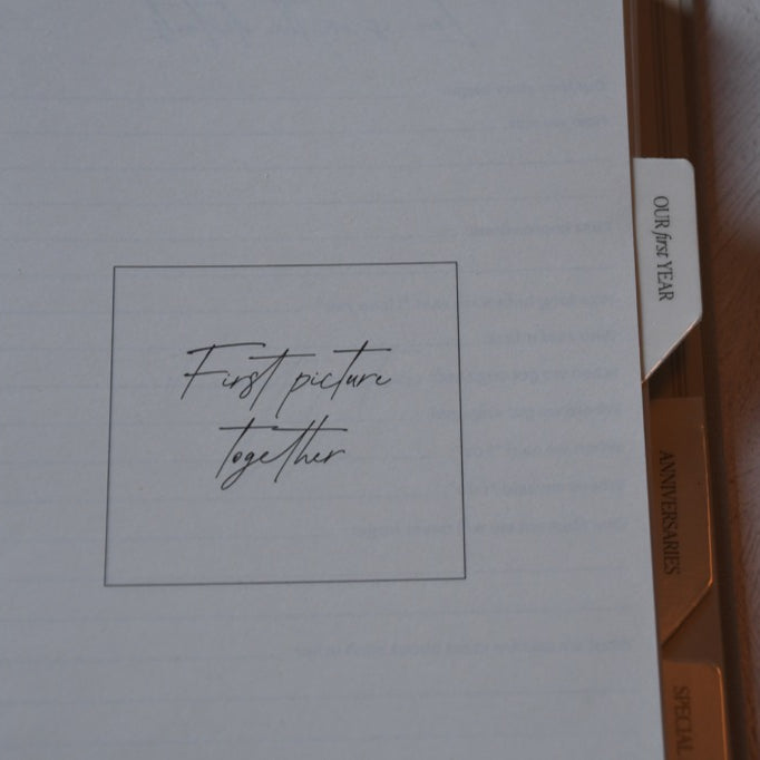 Notebook with 'First picture together' text on a plain background