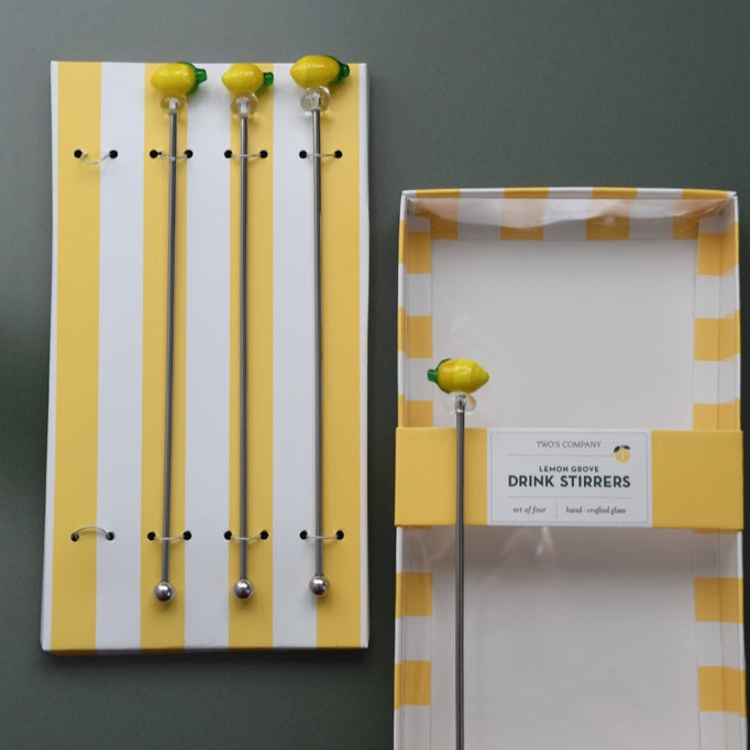 Packaging of lemon-themed drink stirrers with yellow and white striped design on a gray background.