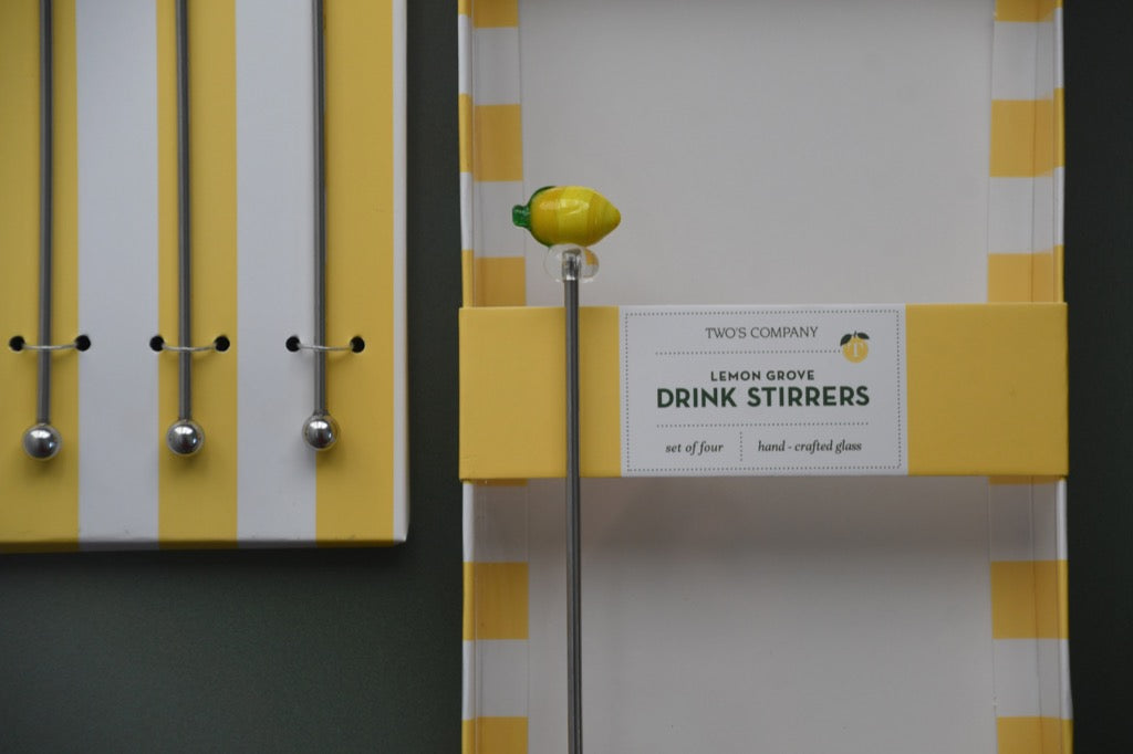 Packaging of drink stirrers with lemon design on a gray background
