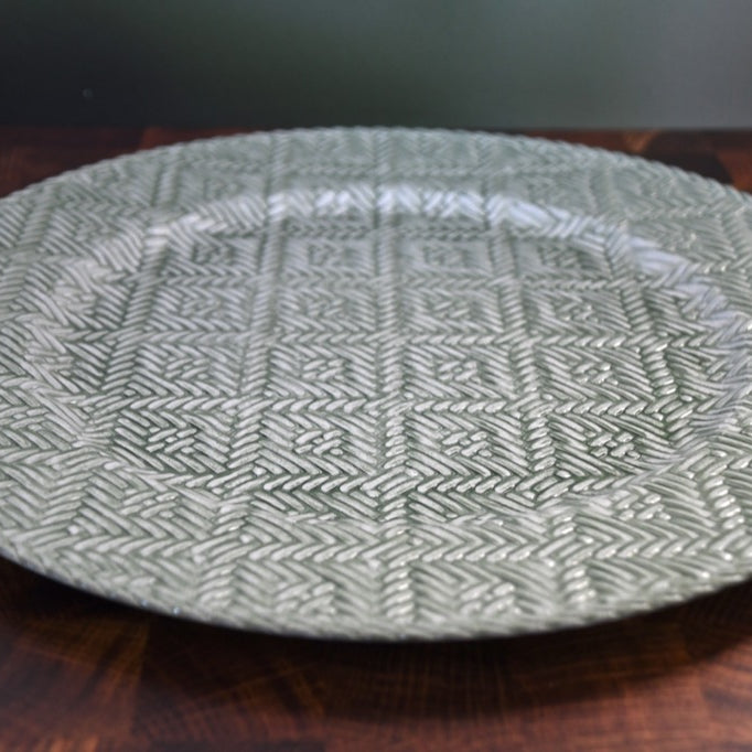 Round woven placemat on a wooden surface