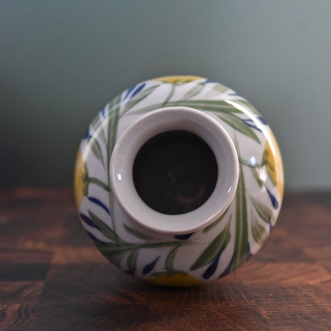 Decorative ceramic vase with floral patterns on a wooden surface