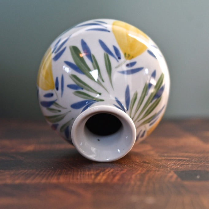 Ceramic vase with leaf pattern on a wooden surface