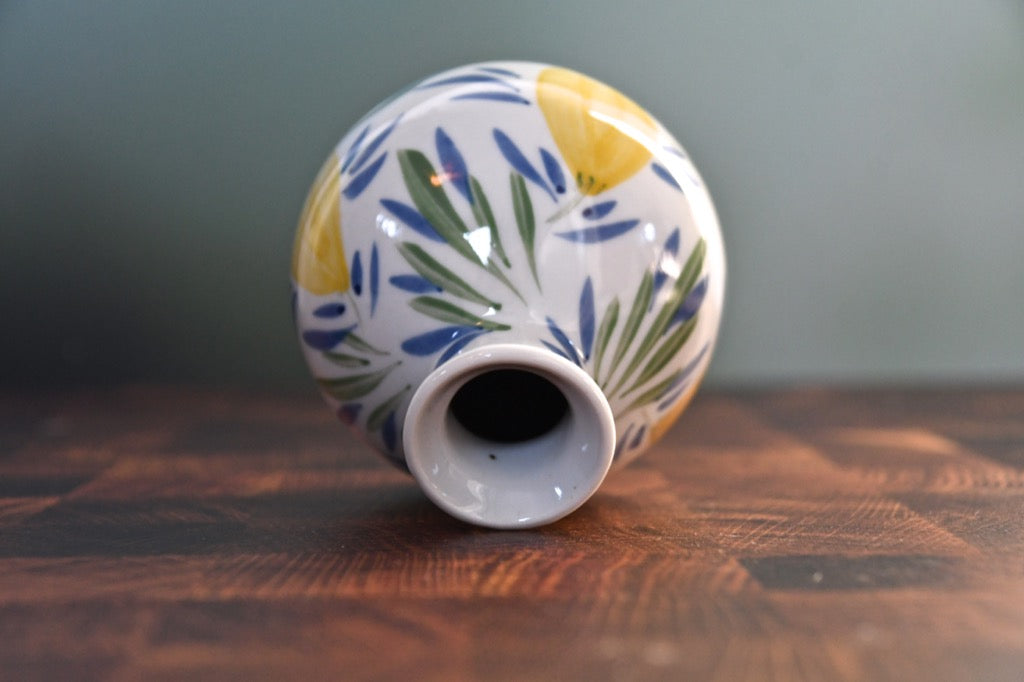 Ceramic vase with leaf pattern on a wooden surface