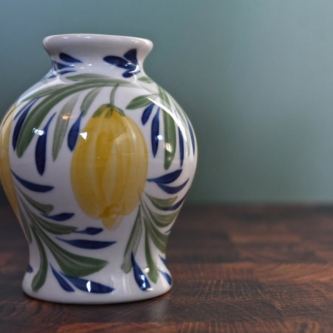 Decorative ceramic vase with lemon design on a wooden surface