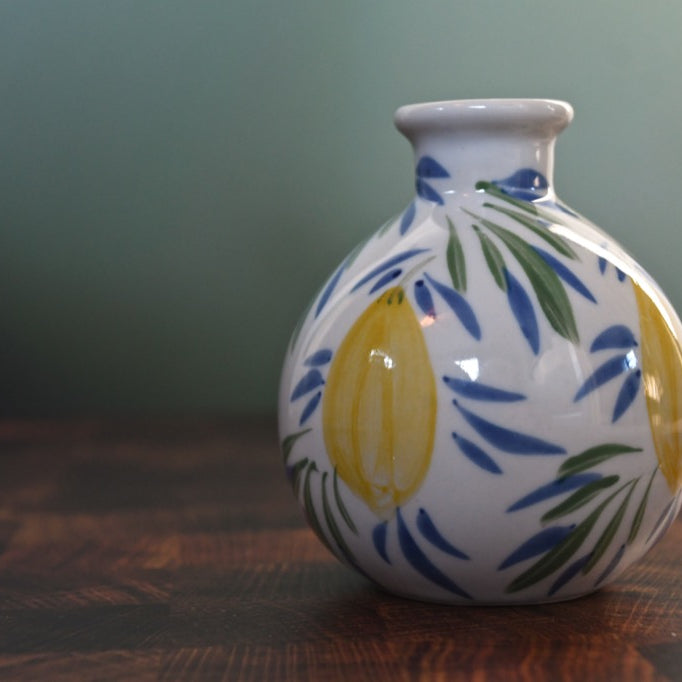 Ceramic vase with floral design on a wooden surface