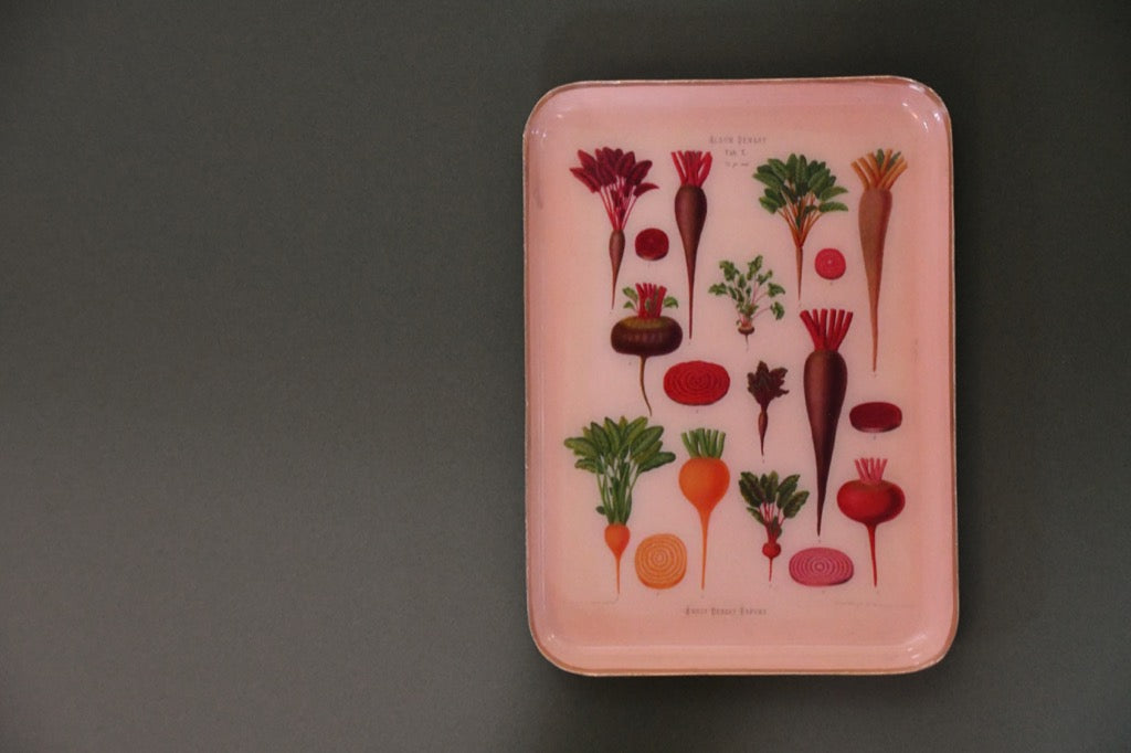 Peach tray with vegetable illustrations on a gray background