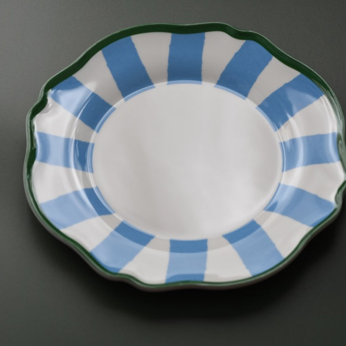 Plastic plate with blue and white striped rim on a dark background
