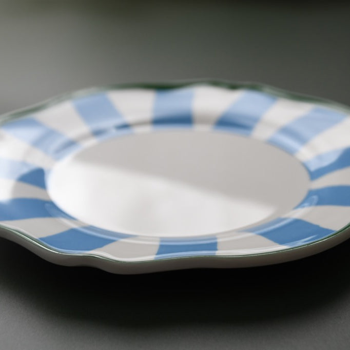 plastic plate with blue and white striped rim on a dark background