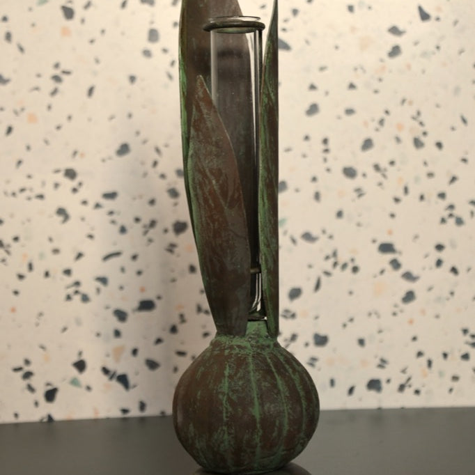 Bronze sculpture with a textured surface on a speckled background