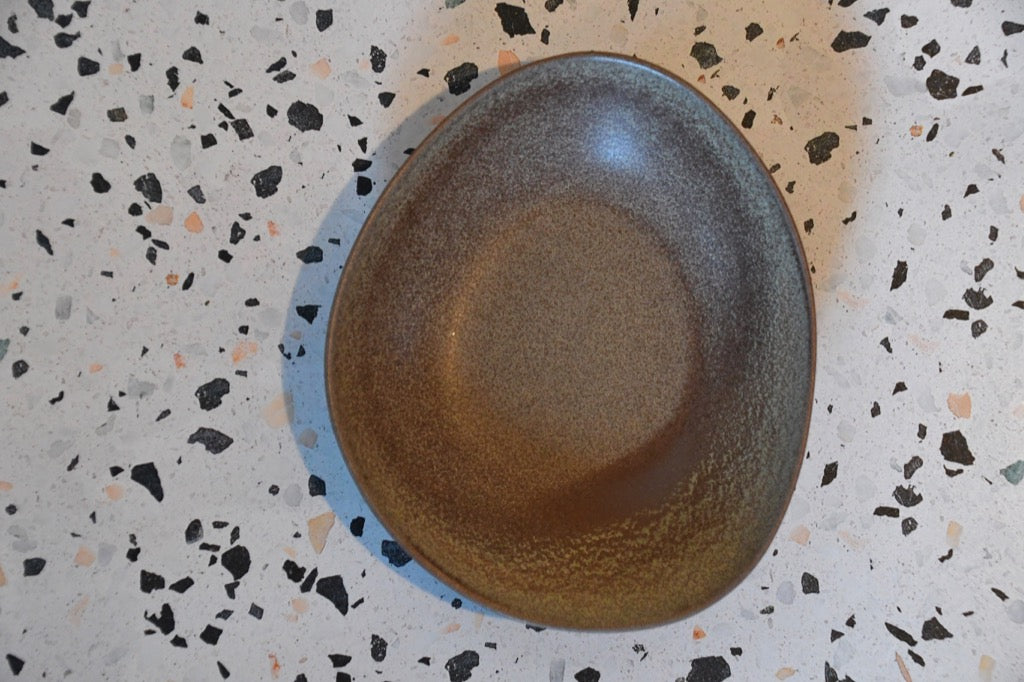 Brown ceramic plate on a speckled surface