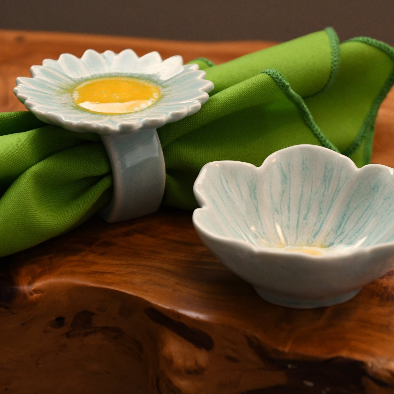 Decorative ceramic items on a wooden surface with green fabric