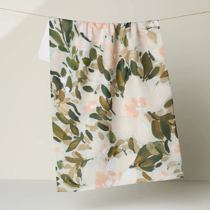 Floral patterned fabric hanging on a line against a neutral background
