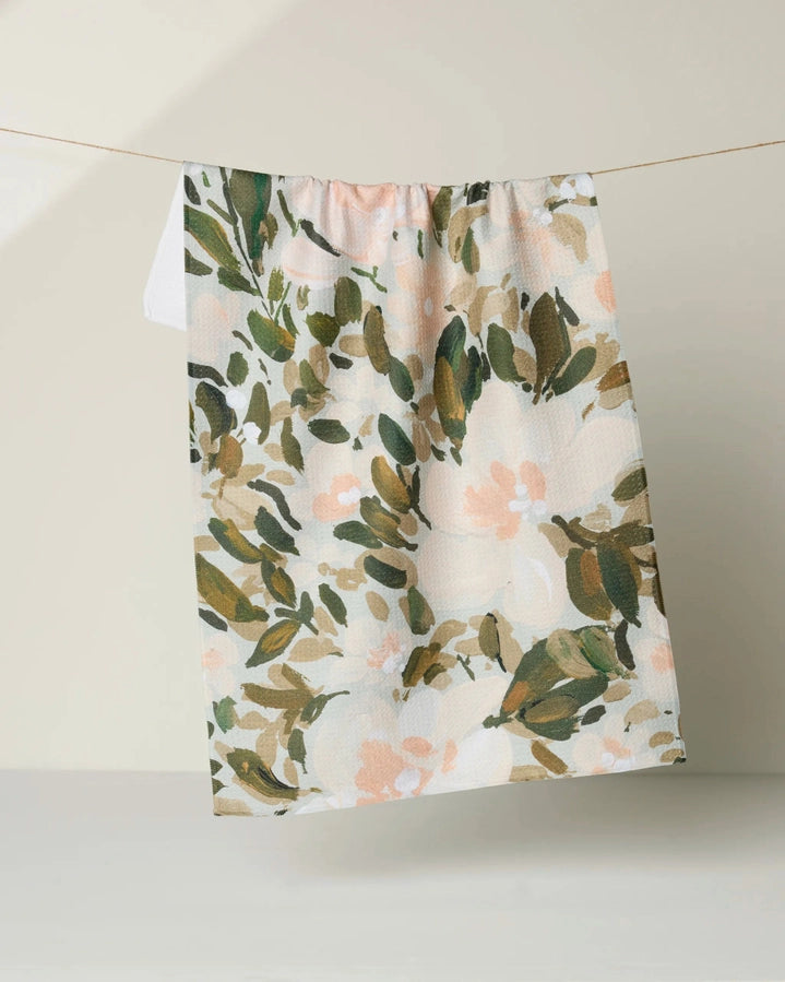 Floral patterned fabric hanging on a line against a neutral background