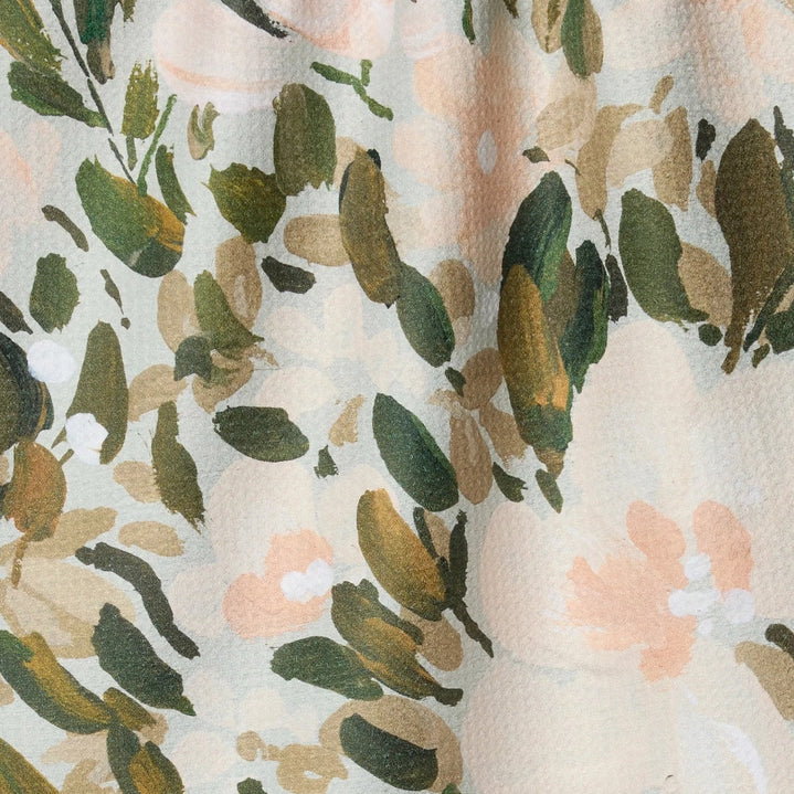 Floral patterned fabric with green leaves and pink flowers on a beige background